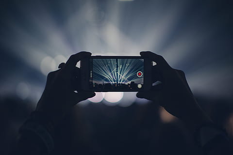 person holding smartphone with two hands filming a concert HD wallpaper