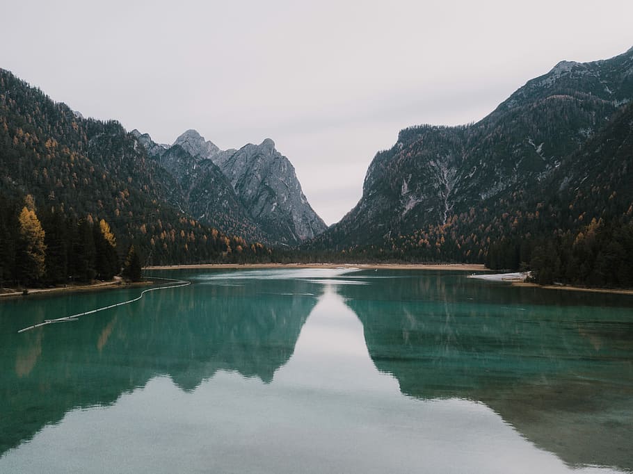 bodies of water near mountains under why sky at daytime, body of water surrounded by mountains and trees HD wallpaper