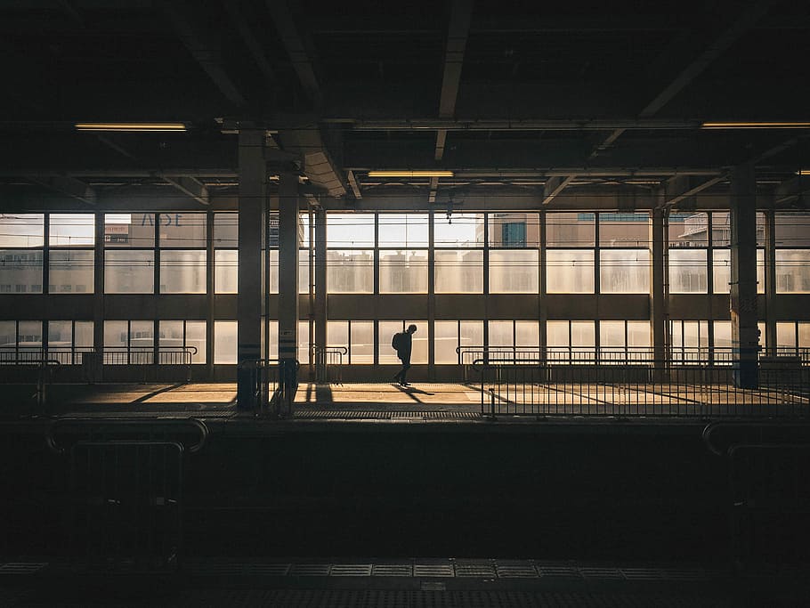 man standing inside building near window, silhouette photo of train station HD wallpaper