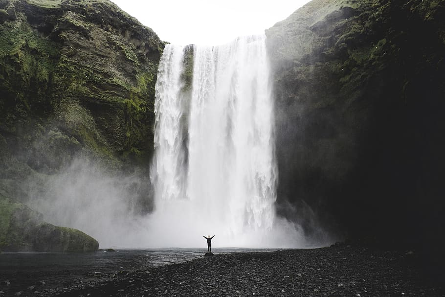 person under the waterfalls, person standing in front of waterfalls HD wallpaper