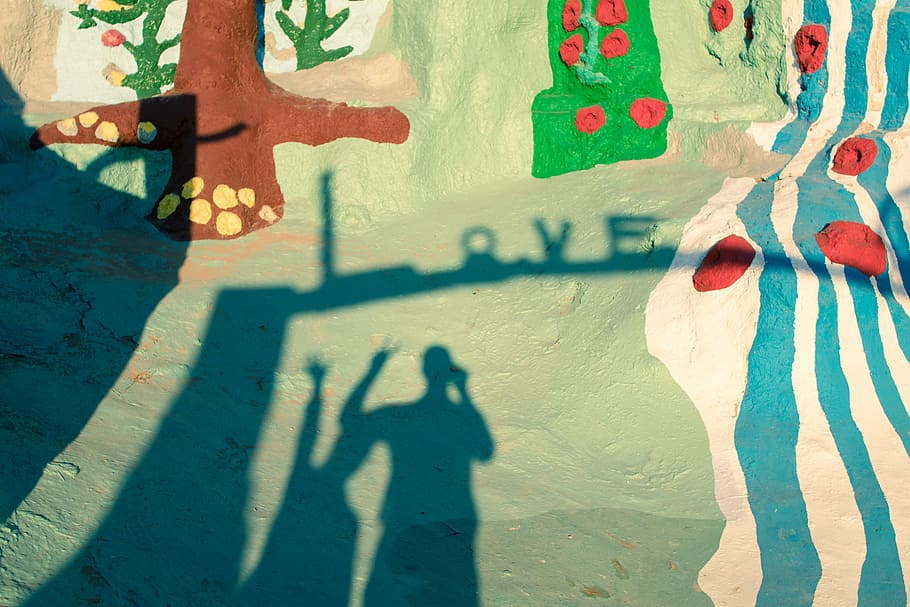 shadow of two person standing during daytime, photo of graffiti artwork during daytime HD wallpaper