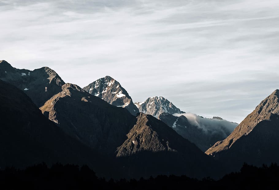 rocky mountain covered with fog taken at daytime, brown and gray mountains under white clouds HD wallpaper