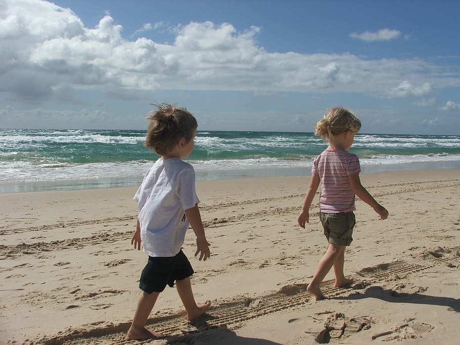 two toddlers walking on seashore, queensland, australia, beach