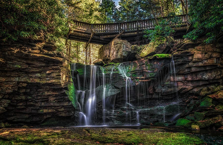 waterfalls near wooden bridge and trees wallpaper, time-lapse of waterfall under brown wooden bridge taken at daytime HD wallpaper