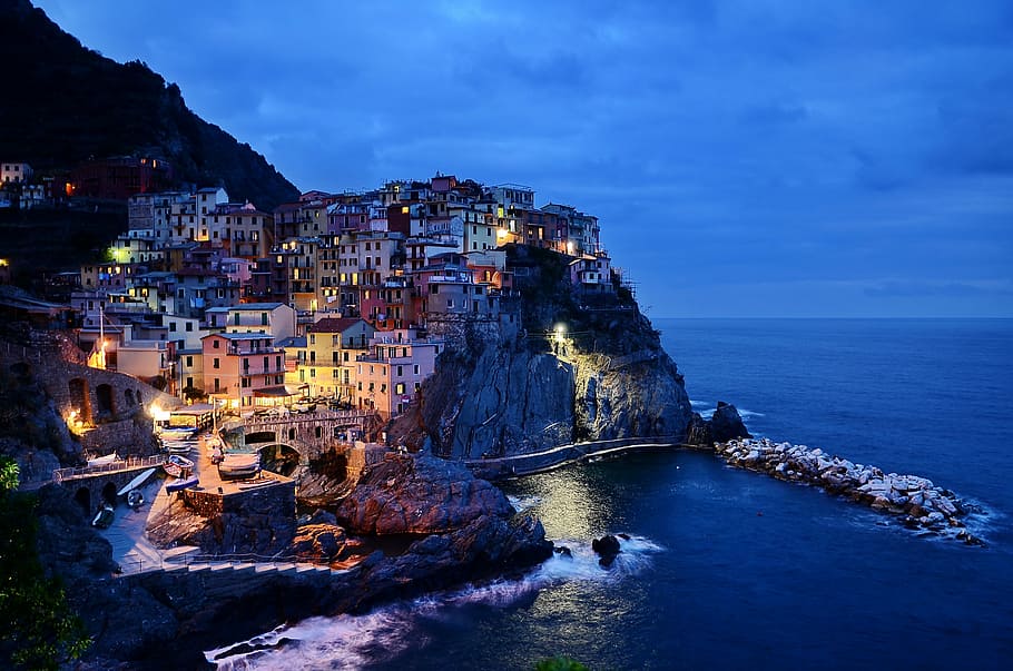 beach, buildings, city, cliffside, coast, lights, night, ocean HD wallpaper