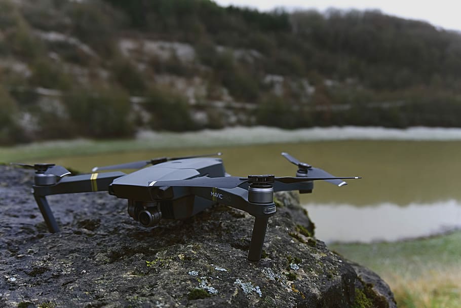 black quadcopter on rock, black DJI Spark drone on gray rock during daytime HD wallpaper