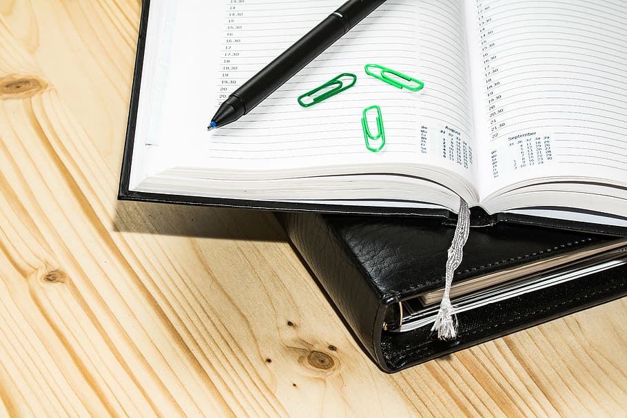 black ballpoint pen beside three green clips on white book page, HD wallpaper