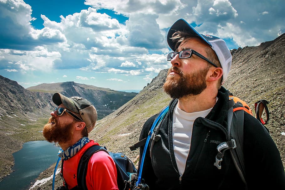 two male hikers looking up at the sky, two man on mountain near lake HD wallpaper