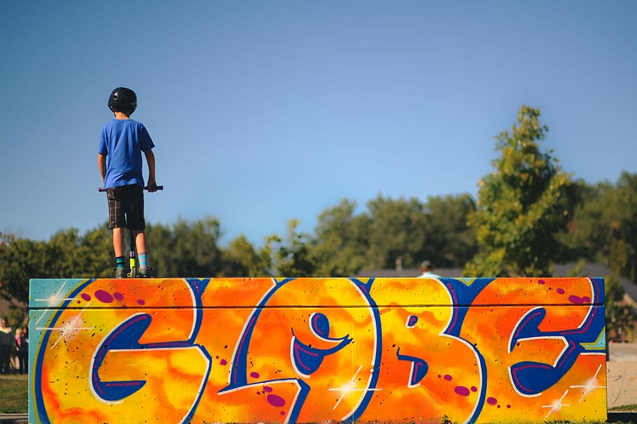 rule of thirds of boy standing facing backwards, boy playing kick scooter