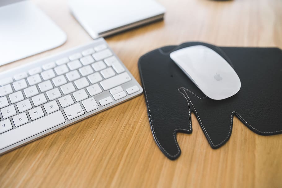 White Apple mouse and keyboard on the black Elephant Pad, black pad