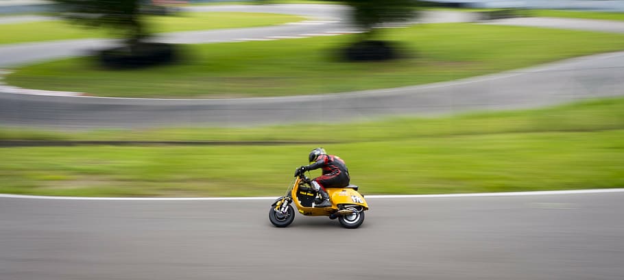 person riding yellow motor scooter on concrete road, vespa, race, HD wallpaper