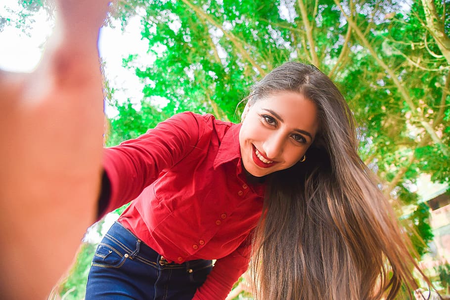 Smiling Woman in Red Shirt and Blue Jeans Taking Selfie Under Green Leaved Tree, HD wallpaper