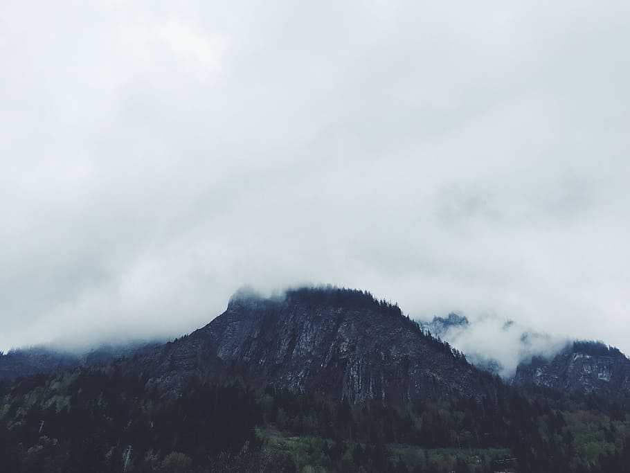 photo of clouds covering mountain, brown mountains surrounded by green trees HD wallpaper