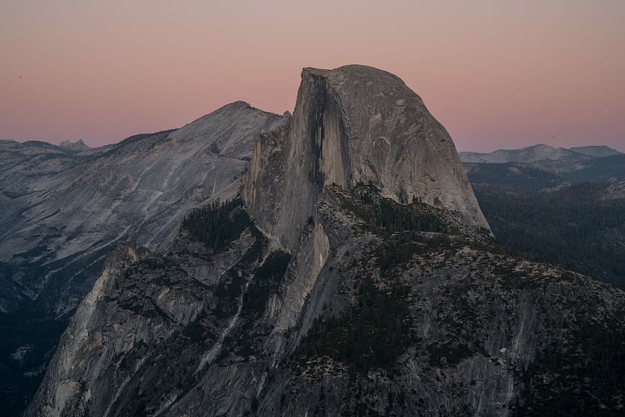 grey rock formation under cloudy skies, aerial photography of mountain range during golden hour HD wallpaper