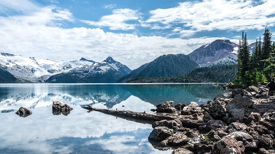 snow covered mountains near lake under cloudy blue sky, trees HD wallpaper