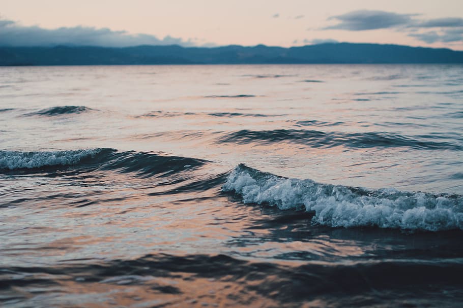 mountain and body of water photo, landscape photography of calm sea waves during golden hour HD wallpaper