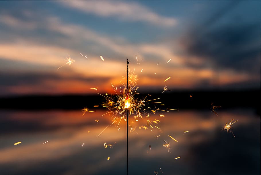 shallow focus photography of fireworks, selective focus photography of sparkler firework under blue and white sky HD wallpaper