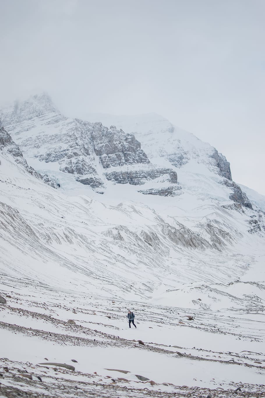 person trekking on icy mountain, person in gray jacket on beside of snowy mountain during daytime HD wallpaper