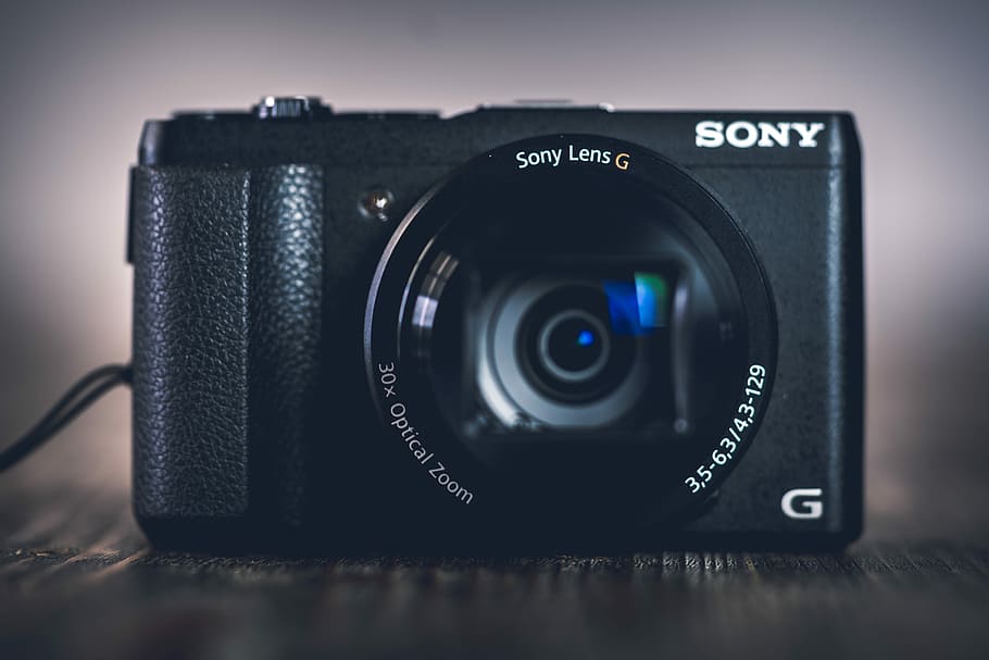 black Sony G point-and-shoot camera, black Sony G-series point-and-shoot camera on gray surface