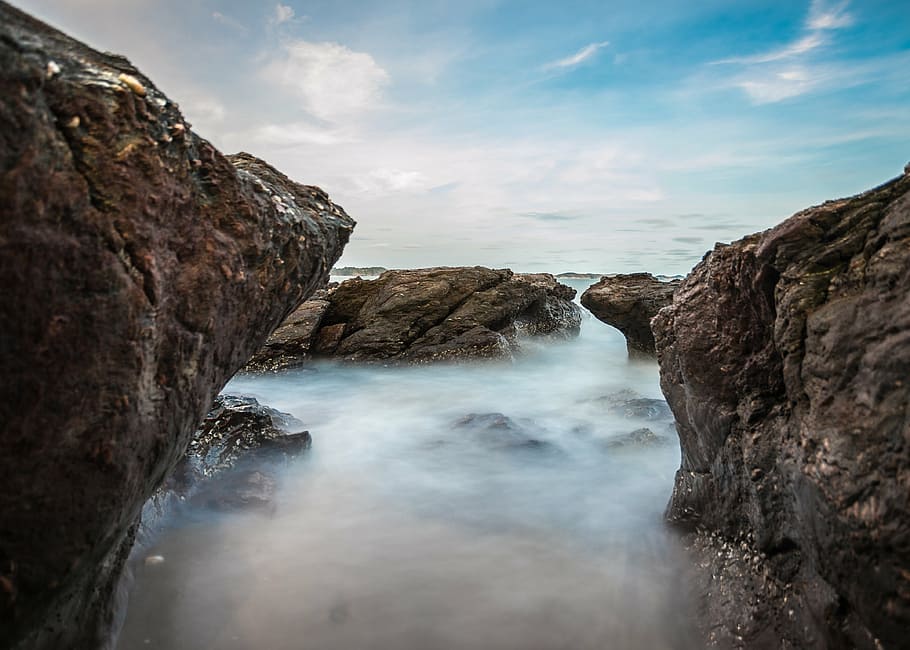 waterfalls between rock boulders, sea, sky, blue, rocks, fog HD wallpaper