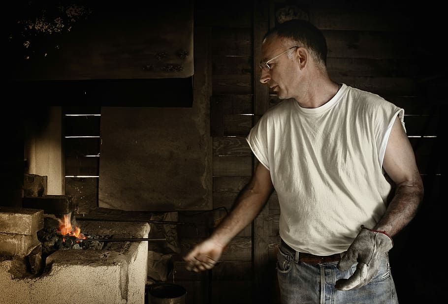 man standing near burner, man in white sleeveless shirt forging metal HD wallpaper