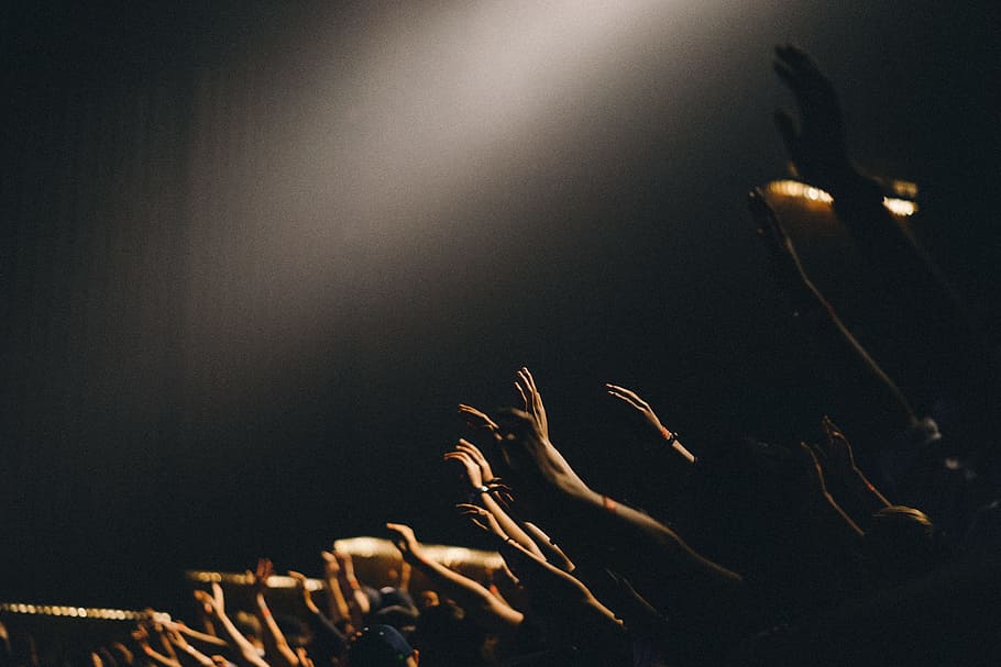 group of people waving their hands, photography of people raising hands in dim concrete building HD wallpaper