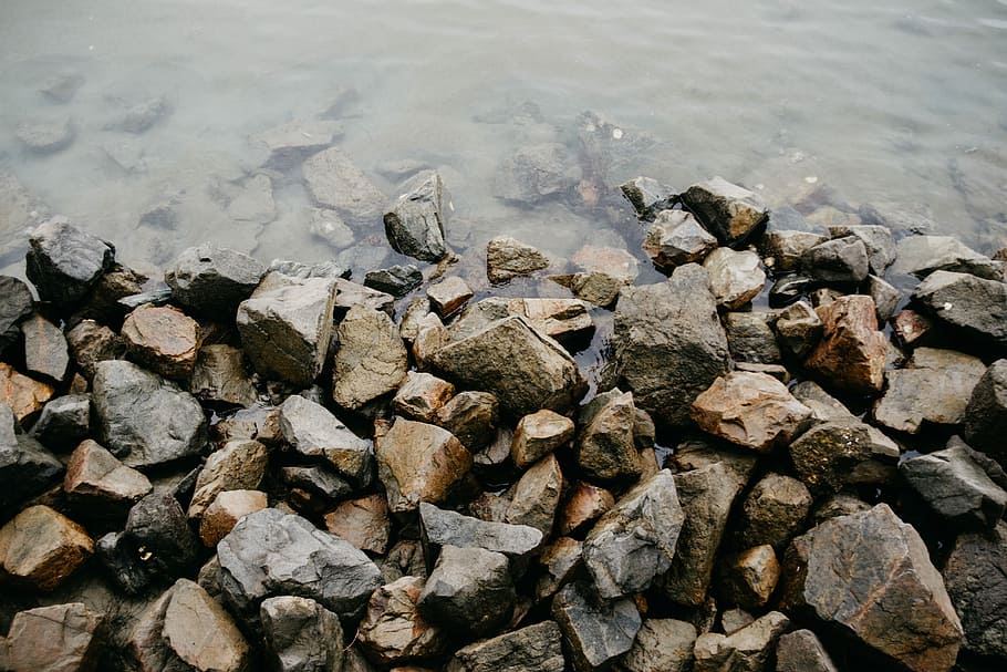 water on top of gray rocks at daytime, brown colored pebbles on seashore HD wallpaper