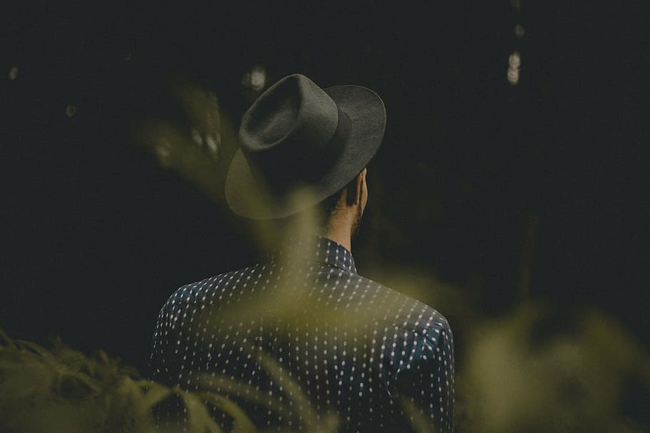 man wearing gray hat and blue collared top standing near grass HD wallpaper