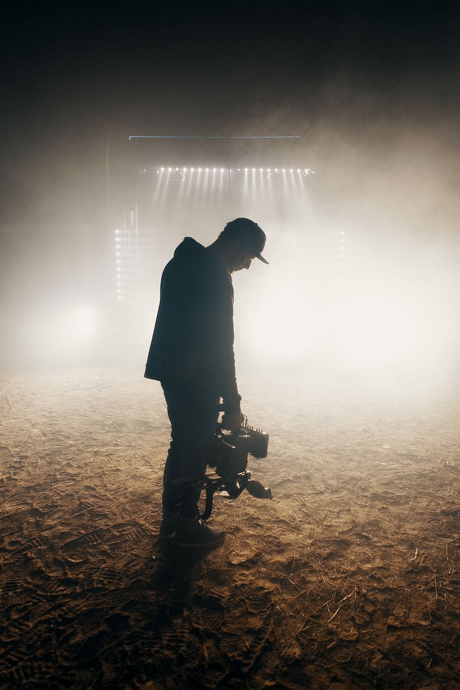 man standing on brown soil wearing cap, man in black jacket holding power tool HD wallpaper