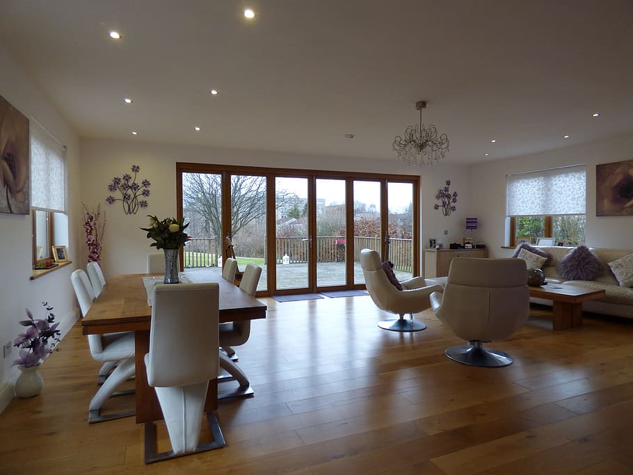 rectangular brown wooden dining table and chairs near leather armchairs