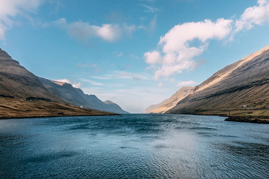 body of water in the middle of brown mountains under clear blue sky, body of water with mountains HD wallpaper