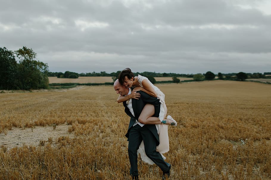 Aly & Tom, man and woman running on brown grass field, bride