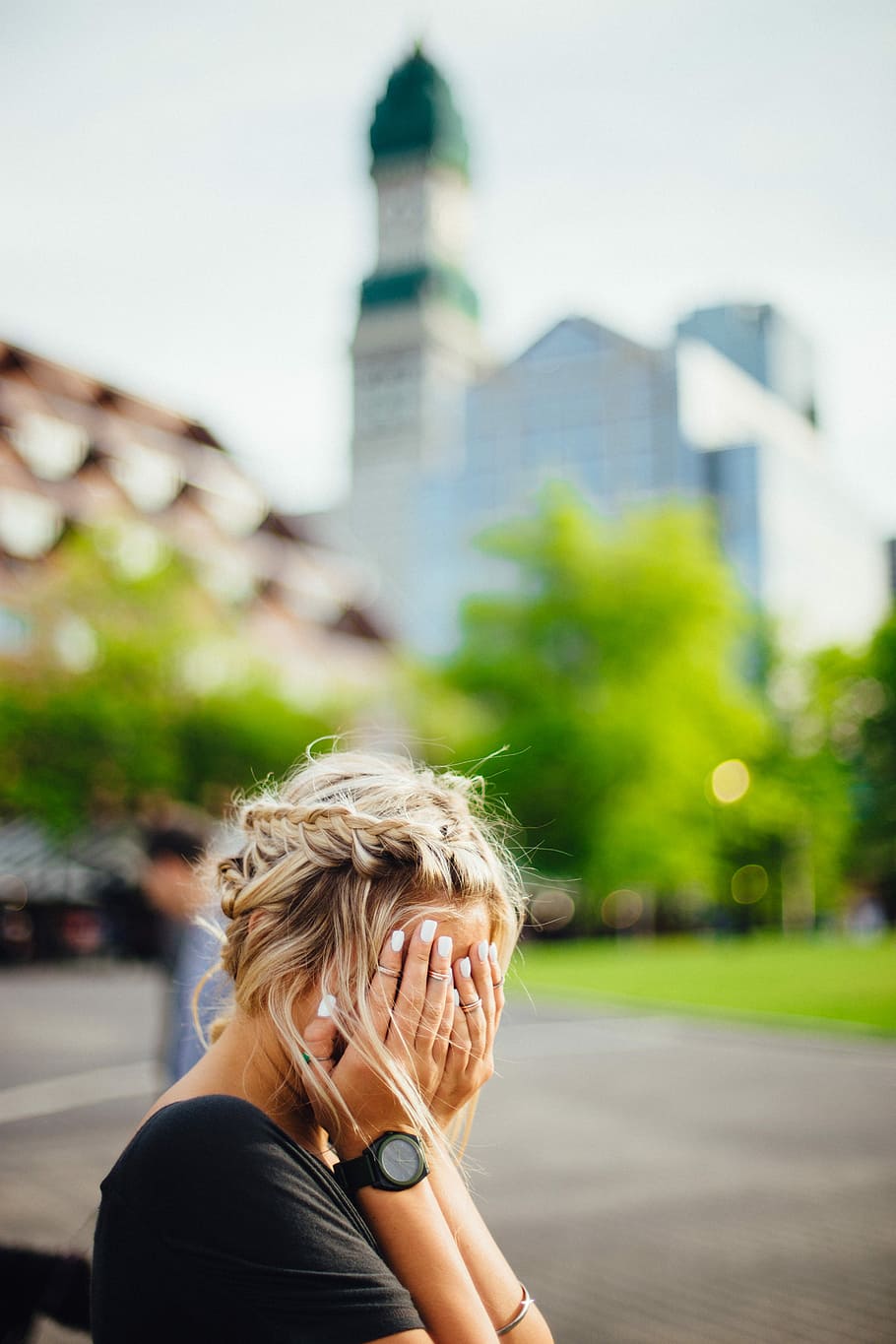 woman wearing black shirt and watch covering her face while sitting during day time HD wallpaper
