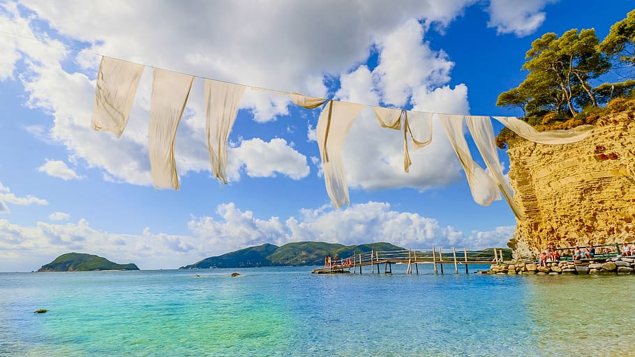 hanging beige textile above body of water during daytime, sea