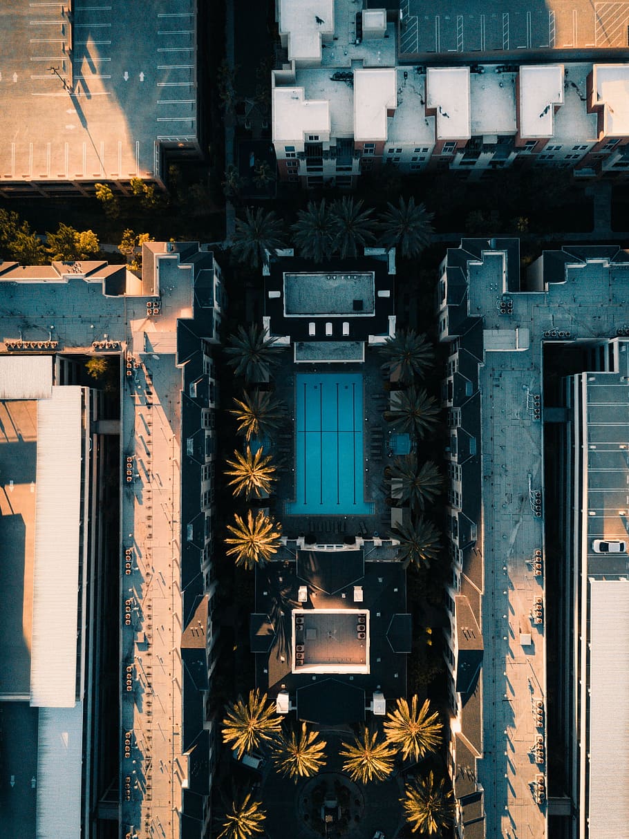 aerial shot of swimming pool surrounded by high-rise buildings during daytime