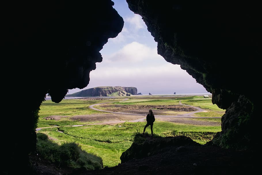 woman standing on rock formation during daytimr, person standing on cave HD wallpaper