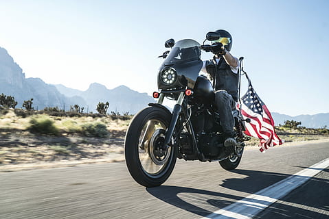 man riding motorcycle with USA flag on back, man riding black touring motorcycle in rule of thirds photography HD wallpaper