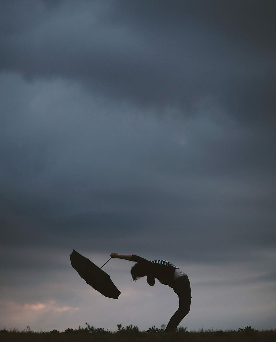 person holding umbrella, person bending his/her body while holding an umbrella HD wallpaper