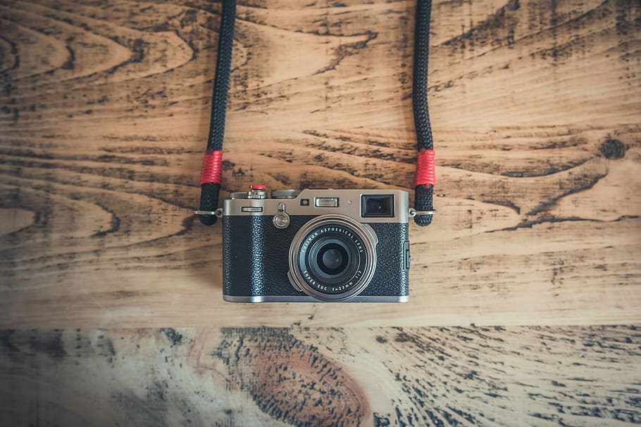 black DSLR camera on top of brown wooden surface, black and gray milc camera HD wallpaper