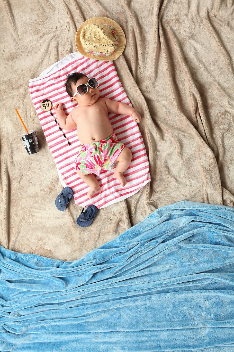 baby lying on red and white blanket with summer-themed photography, HD wallpaper
