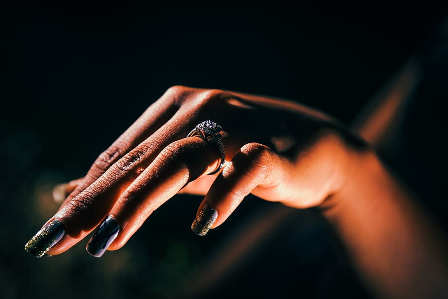 woman showing hand with ring, tilt-shift lens photography of woman's hand with black-and-green floral accent manicure HD wallpaper