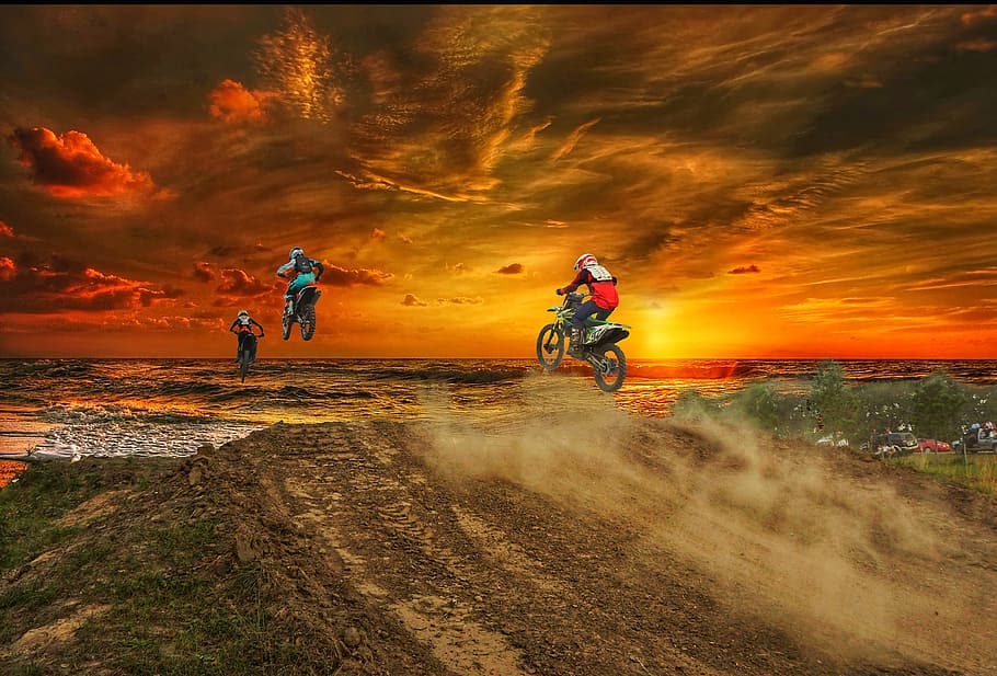 three person riding dirt bikes on mountain, motocross, sunset