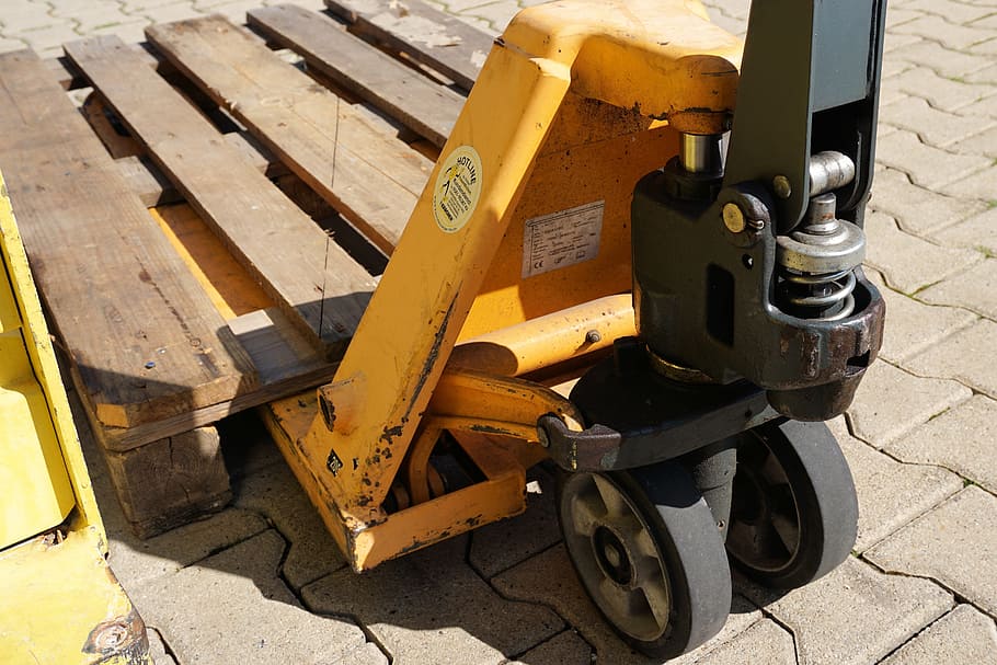 yellow and black pallet truck with wooden pallet on concrete pathway during daytime, HD wallpaper