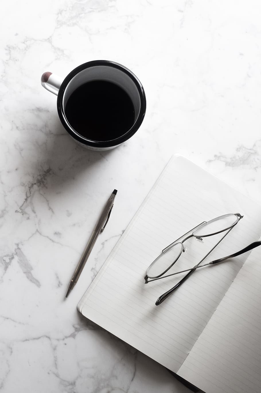 white and black ceramic mug beside notebook with pen and eyeglasses HD wallpaper
