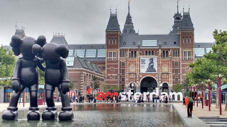 two Kaws statue near building, landmark, amsterdam, holland, architecture
