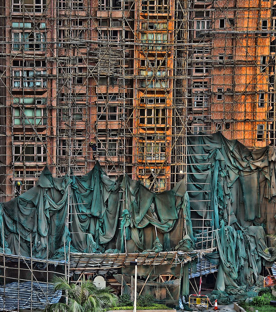 under construction building with scaffoldings, gray metal scaffolding on side of building painting