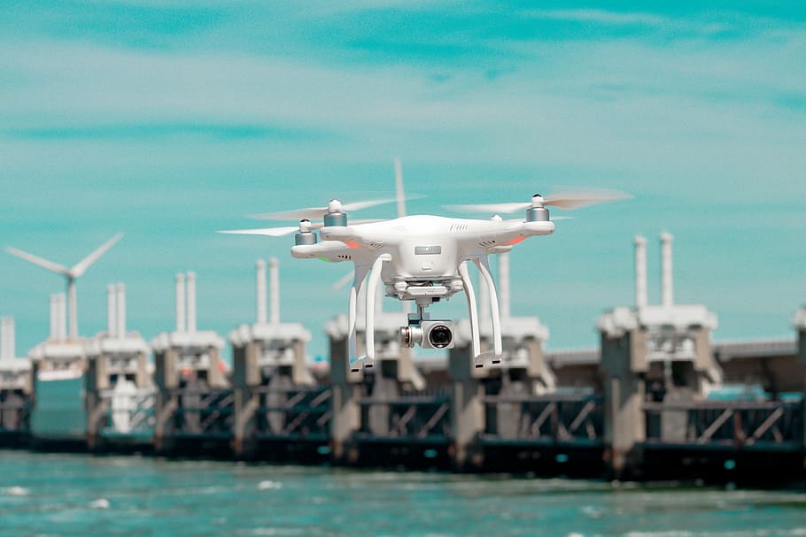 selective focus photography of white drone hovering above body of water, selective focus photography of drone HD wallpaper