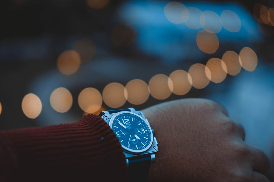 bokeh photography person wearing round silver-colored chronograph watch, person wearing silver-colored chronograph watch displaying 4:49 HD wallpaper