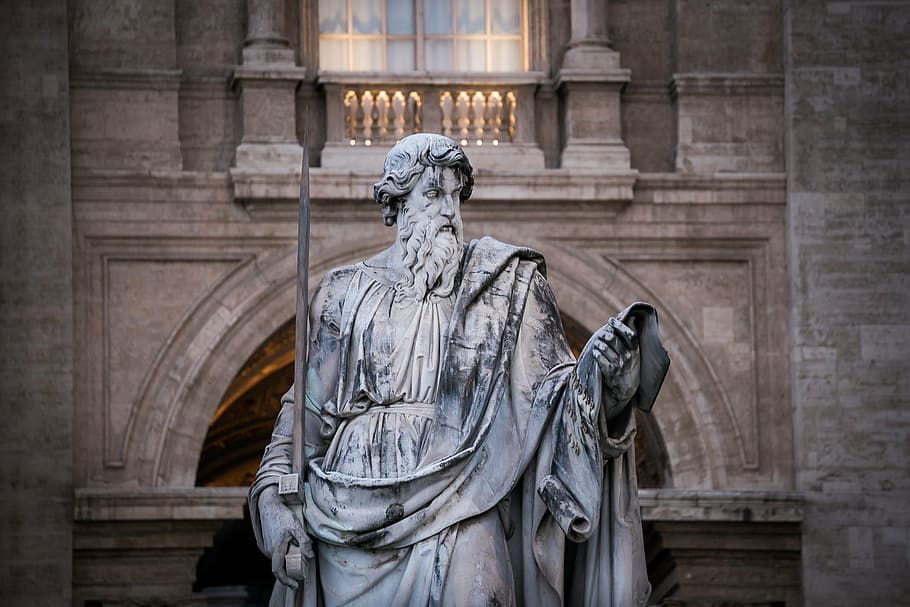closeup photo of man holding bar statue, saint paul, san paolo