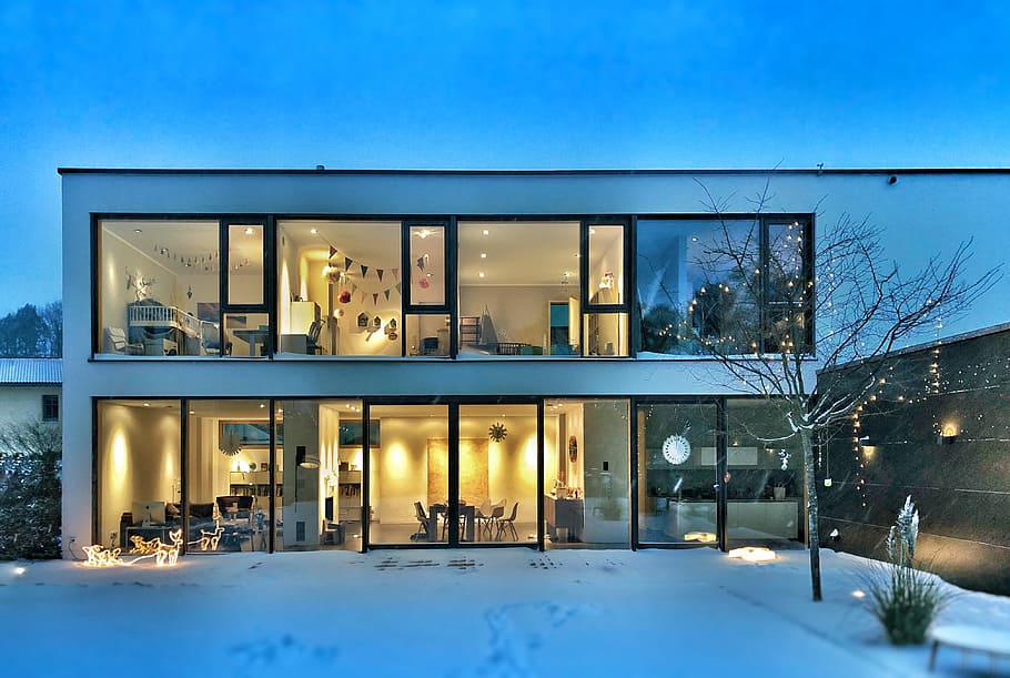 Warm open winter house, glass house across snow covered ground
